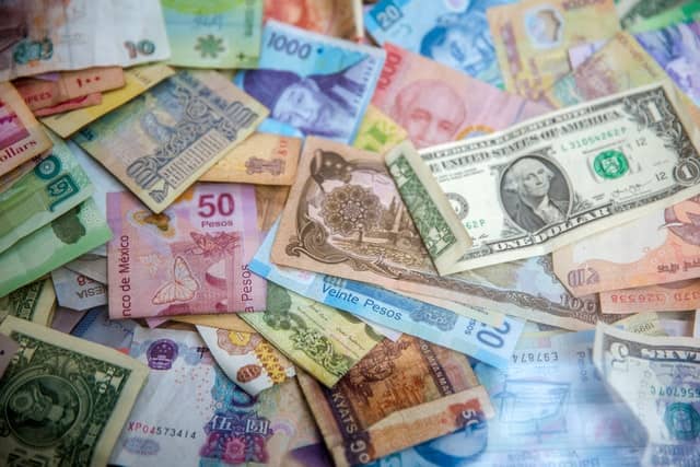 Different countries money scattered across the ground
